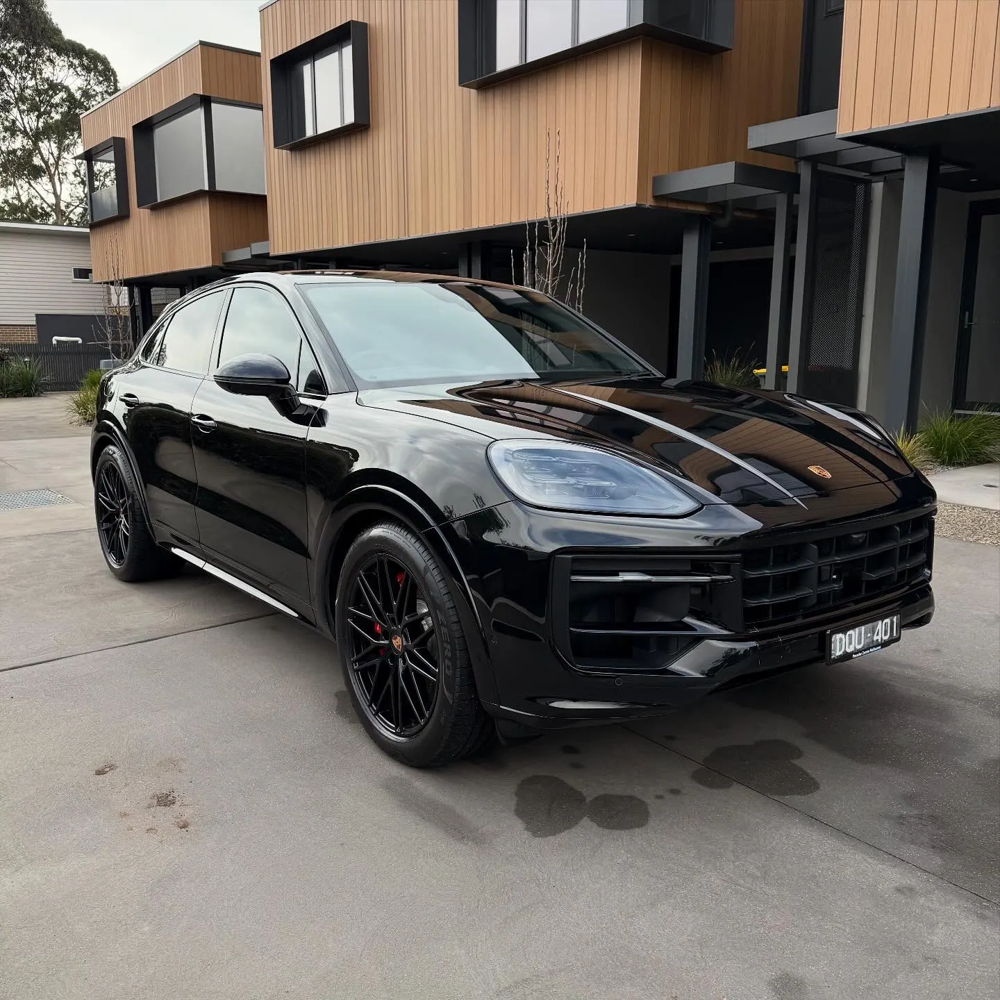 Black Porsche Cayenne GTS finished and polished outside a luxury home